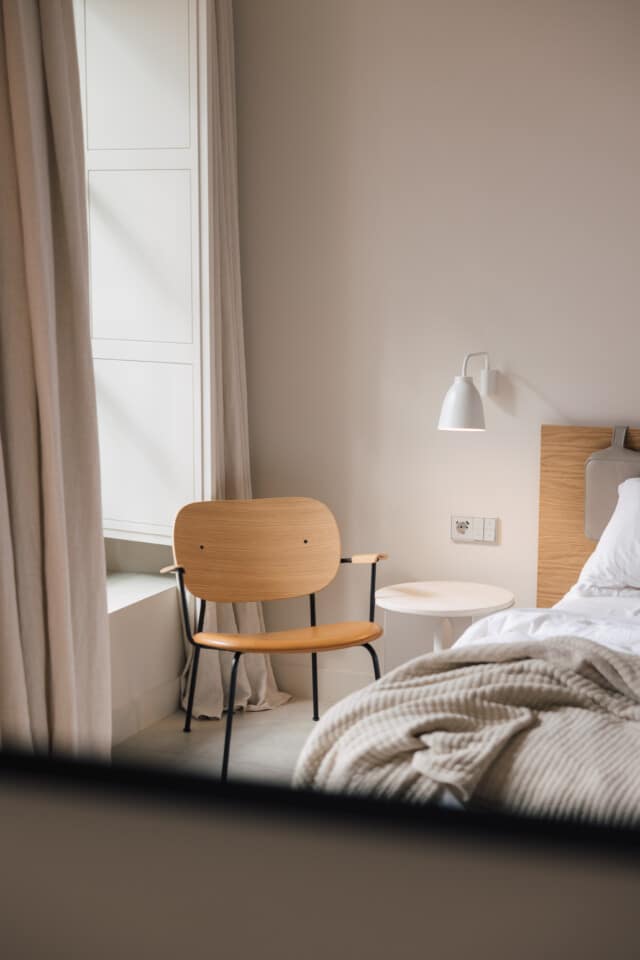 Interior de una de las habitaciones del hotel boutique Plácido y Grata en Sevilla con mobiliario de diseño y materiales naturales.