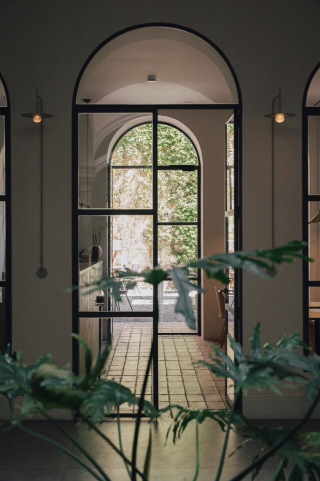 Vista interior del hotel boutique Plácido y Grata en Sevilla con su patio interior en el fondo y plantas en primer plano