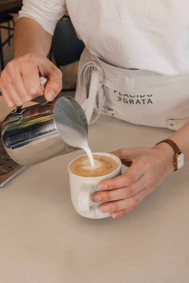 Café de especialidad servido en una de las mesas de la cafetería Plácido y Grata Nido frente al hotel boutique en Sevilla.